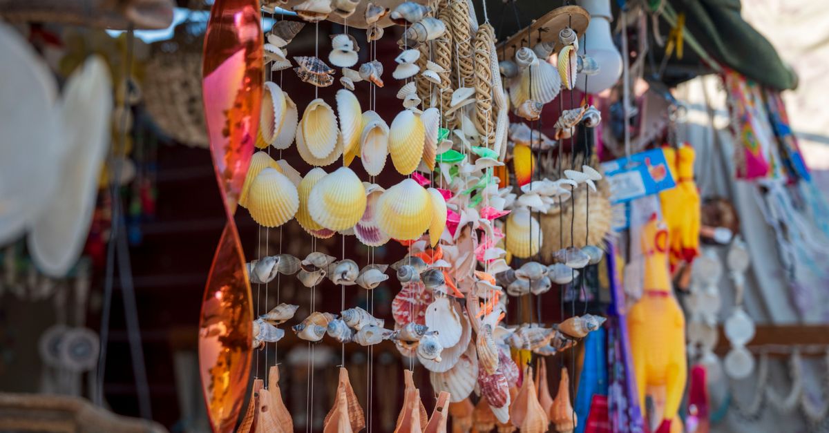Puestos de una feria urbana con objetos de diseño y público recorriendo
